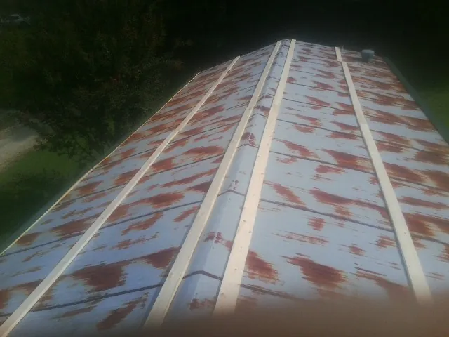 Rusted metal roof panels with new wood purlins before replacement — Storm Damage Roof Repair in Moss by Roofing Brothers