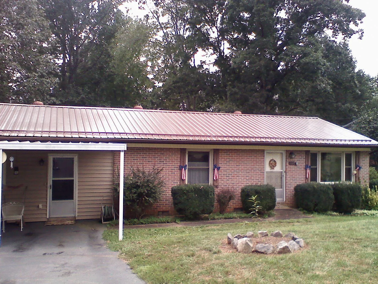Bronze metal roof and carport on a brick ranch home — Roof Repair work by our crew in Moss